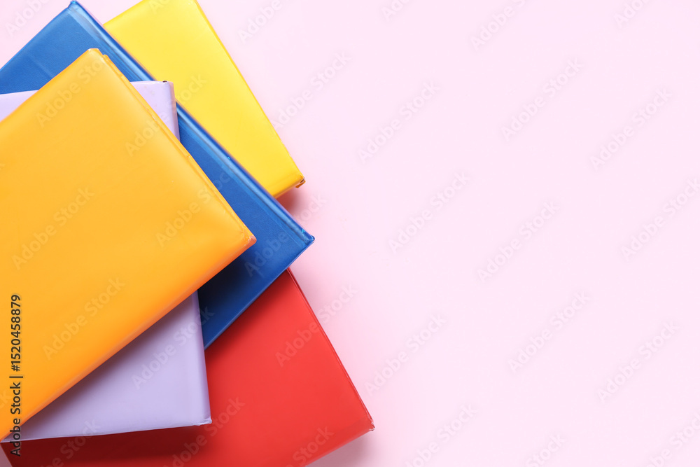 Many colorful books on pink background Many colorful books on pink background