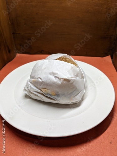 Mini burger on a white plate, with a wood and orange background