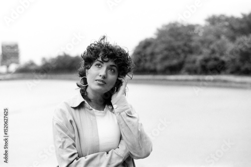 Fotografie Young woman posing by the river in grainy black and white analog photo