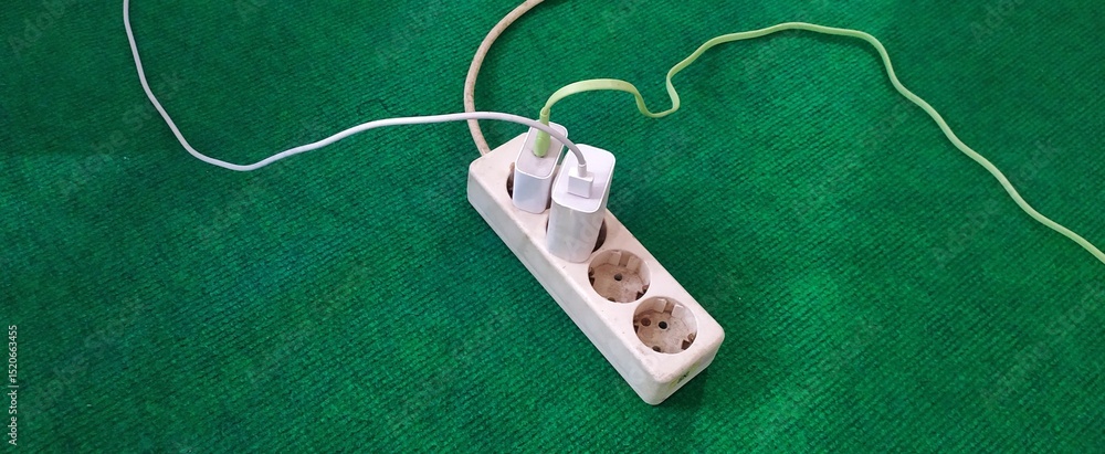 Fototapeta premium photo of handphone charger with data cable plugged into a socket, socket with cellphone charger, white socket, 4 socket