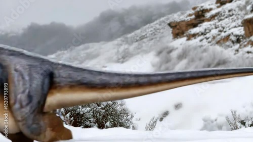 Dinosaur walking through snowy landscape with breathtaking mountain scenery
