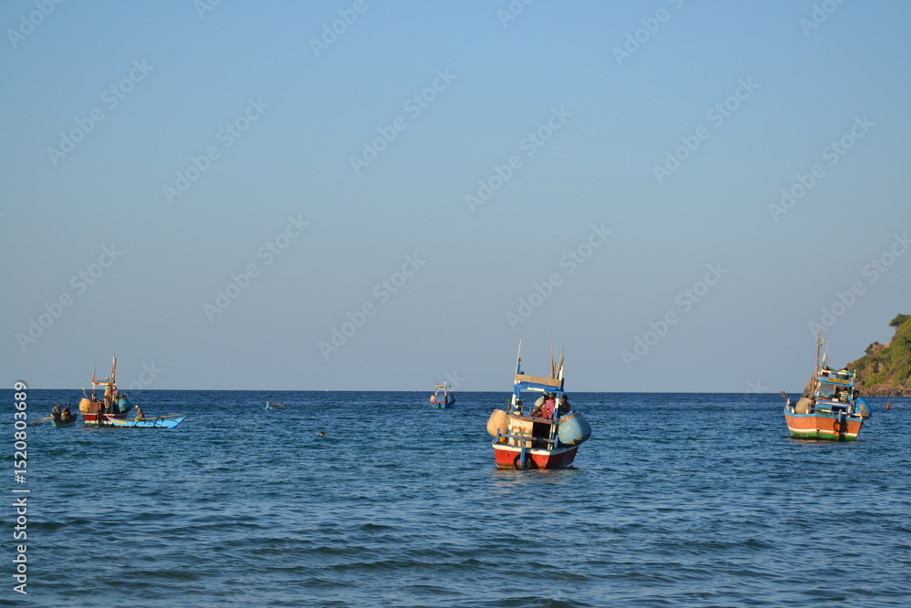 Obraz premium bateau de pếcheurs partant en mer au couché du soleil, Trincomalee, au Sri Lanka