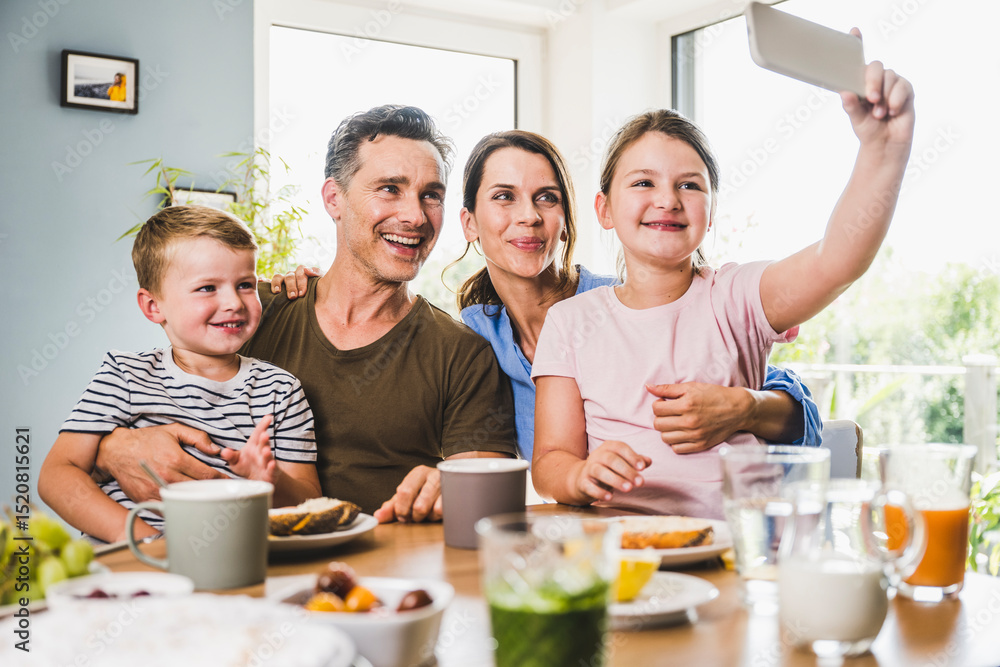 © Westend61 - Girl taking selfie with family through smart phone at home © Westend61 - Girl taking selfie with family through smart phone at home