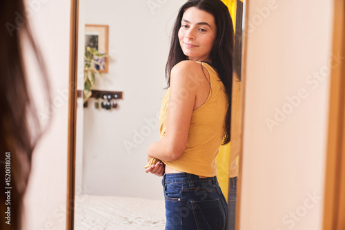 Woman looking in the mirror with confidently
