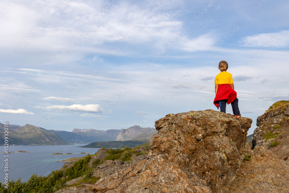 Obraz premium Family with children and pet, hiking Sukkertoppen trail on Senja island, Norway