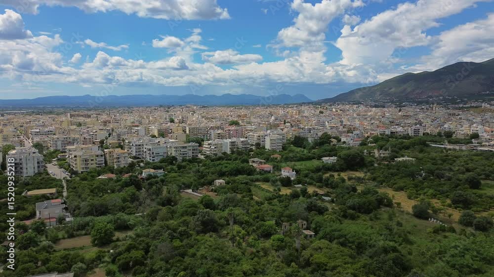 Aerial panoramic view of Kalamata city, spring day, with beautiful white cloud formations on blue sky, green olive orchards on foreground, left pan 4k shot Aerial panoramic view of Kalamata city, spring day, with beautiful white cloud formations on blue sky, green olive orchards on foreground, left pan 4k shot