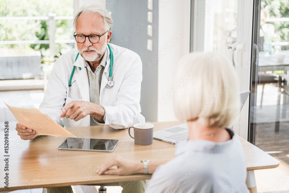 Male doctor discussing with female patient at desk Male doctor discussing with female patient at desk