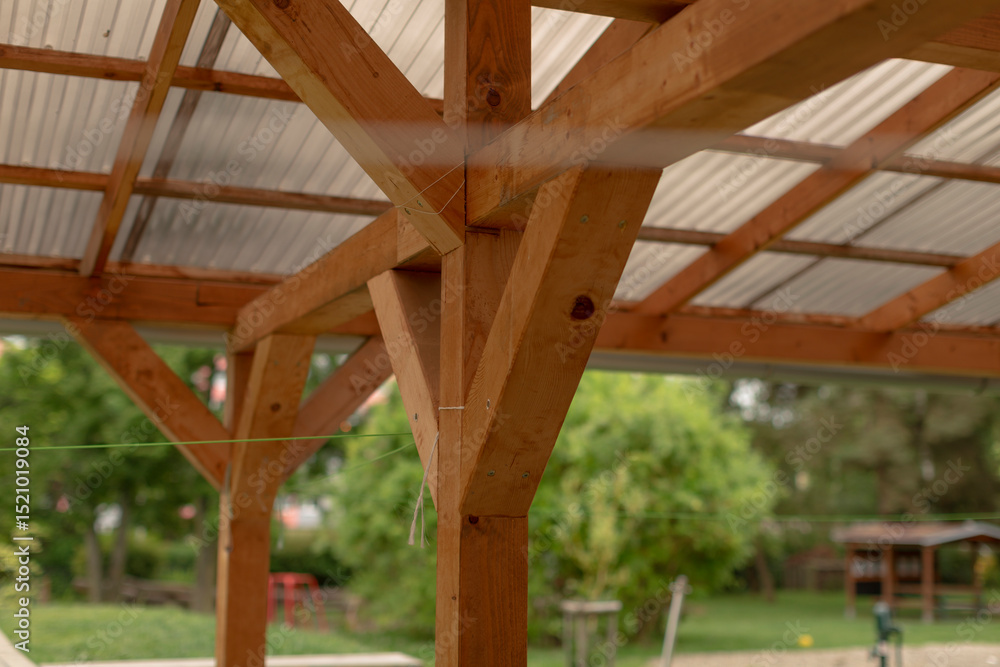 Fototapeta premium This is a detailed view of a beautifully crafted wooden support beam and impressive roof design in a serene patio, showcasing exceptional craftsmanship and enhancing the spaces aesthetic