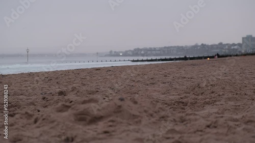 Tranquil beauty of Portobello Beach in Edinburgh during a cloudy sunrise that sets a calm ambiance along the shore.