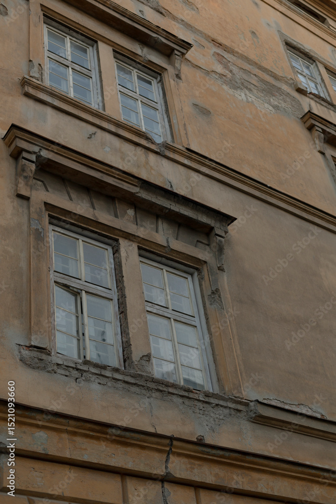 Obraz premium A closeup view of worn and weathered windows on an old building facade, highlighting the intricate architectural details that tell a story of time and history within the structure