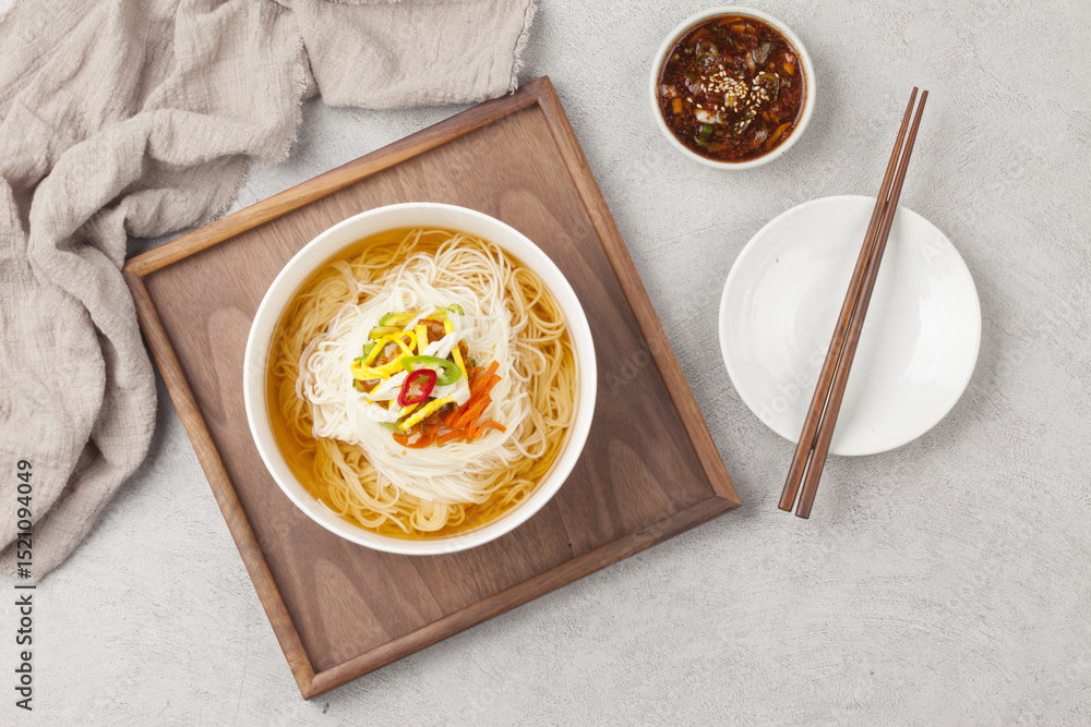 Naklejka premium Janchi Guksu refers to noodles that are mainly eaten on feast days. It is a dish made with noodles in a hot clear soup and various toppings.
