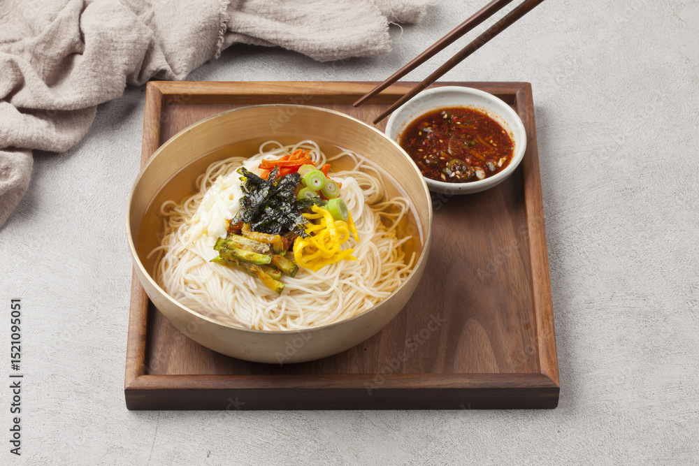 Naklejka premium Janchi Guksu refers to noodles that are mainly eaten on feast days. It is a dish made with noodles in a hot clear soup and various toppings.