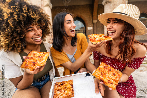 Photography Three young female friends eating pizza sitting outside - Multiracial women enjo