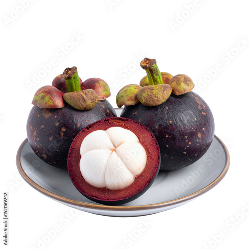 Fresh mangosteens on plate with one cut open