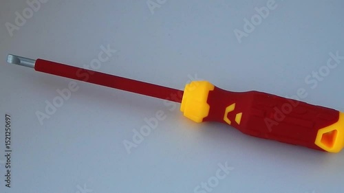 Dielectric screwdriver with insulated rod. Close-up. Isolated on grey background.