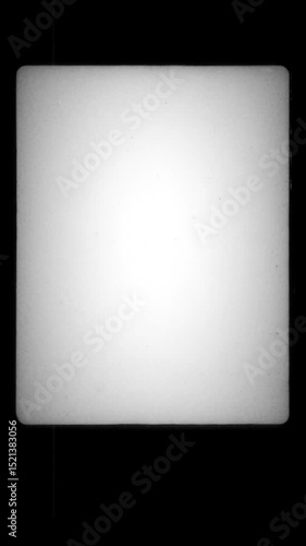 Vertical Vintage Film Frame with White Glow and Black Border. Empty Retro Frame with Subtle Grain and Soft Edges. Classic 16mm Look with Film Strip Texture and Light Vignette. Vertical Video. FL0136