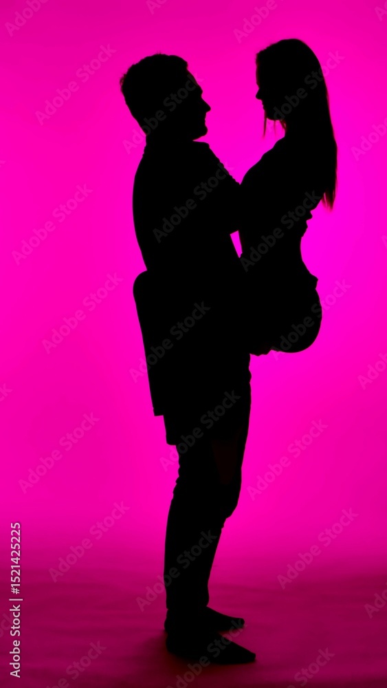 Silhouette of Couple in Romantic Pose Against Pink Background Silhouette of Couple in Romantic Pose Against Pink Background