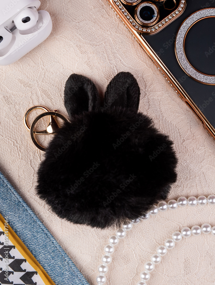 Fototapeta premium Close up of cute fluffy black bunny bag keychain ,flat lay from women bag