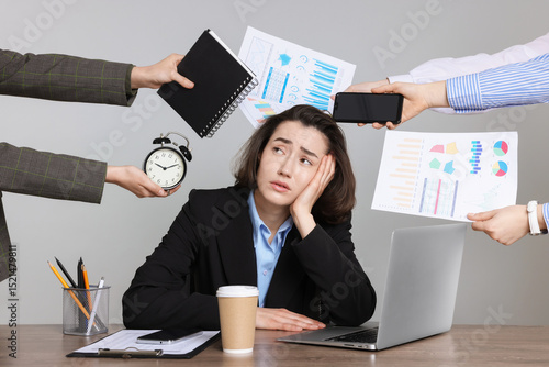 Tablou pe pânză Woman overwhelmed by different requests from colleagues at desk against gray bac