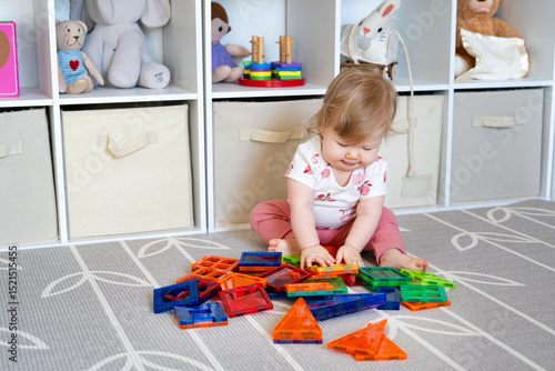 Adorable Baby Girl Playing with Colorful Magnetic Tiles on Nursery Floor, Learning Shapes, Early Childhood Development, Educational Toy Concept, Montessori Inspired Playroom. 
