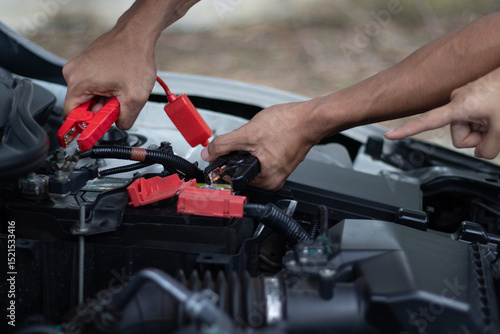 Fotografi Professional male technician checks broken car engine using tools to diagnose power problems and initiate emergency car repair service