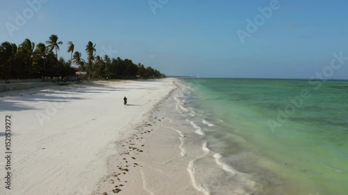A motor cyclist rides along Paje beach in Zanzibar.