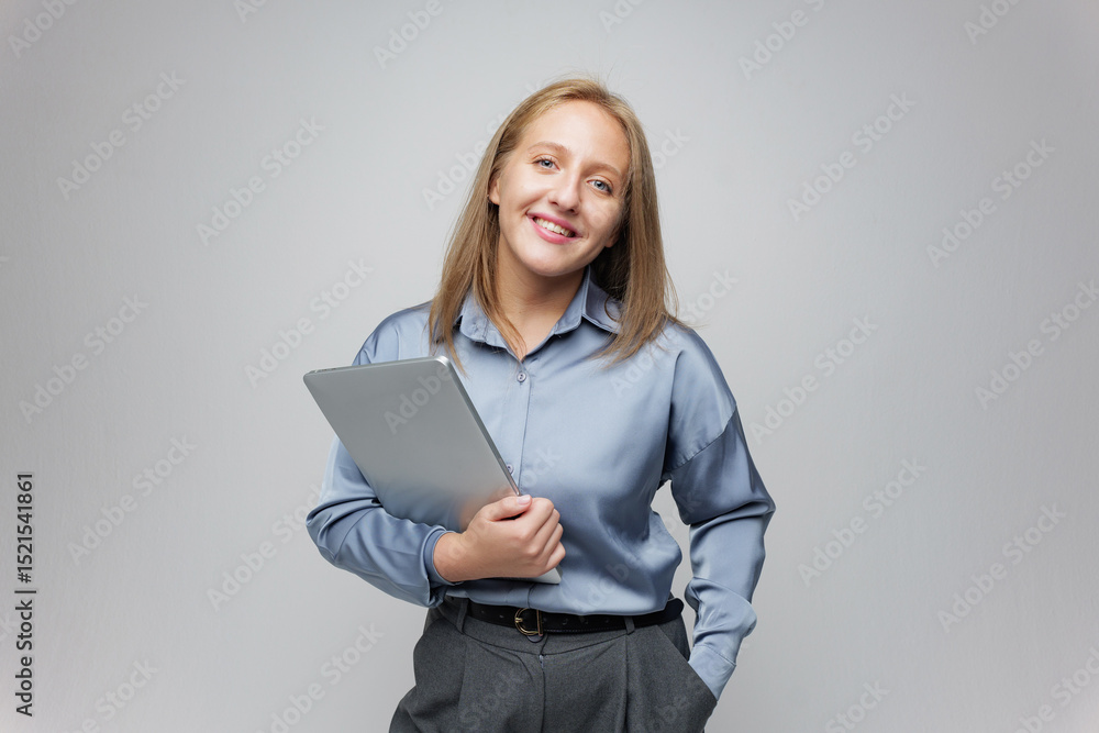 Smiling Young Professional Holds Tablet While Showcasing a Confident Demeanor in a Modern, Minimalistic Indoor Setting Smiling Young Professional Holds Tablet While Showcasing a Confident Demeanor in a Modern, Minimalistic Indoor Setting