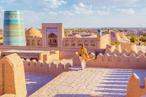 Woman in a traditional robe admires the town of Ichan-Kala.