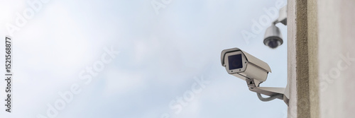 Long banner, Close-up of a security camera on a multi-story building.