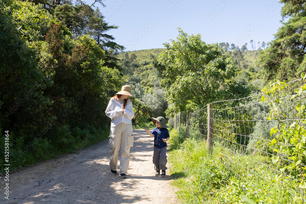 Fototapeta premium Mother and son enjoying a walk in nature on a sunny summer day