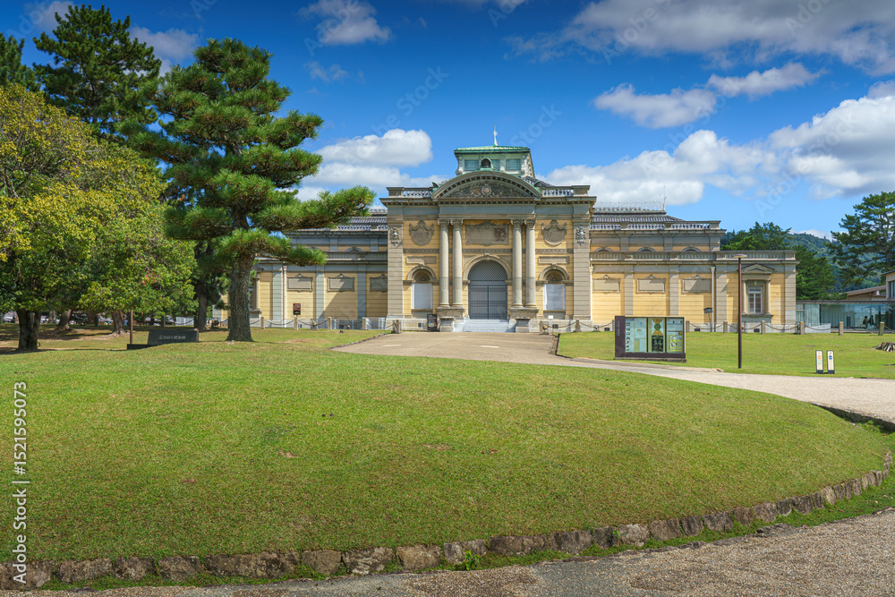 Obraz premium Nara, Japan - Sep 26 2024, panoramic view of the garden in front of the National Museum of Nara, with museum building on background, at daytime with blue sky, without people, Nara, Japan