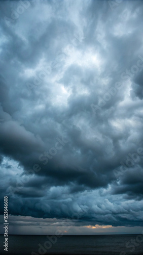 Dramatic overcast sky with dark storm clouds gathering above the calm ocean waters