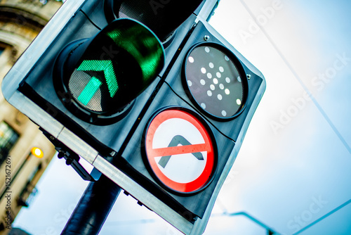 close up of UK Traffic light with green arrow pointing up and no right turn sign