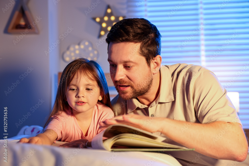 Obraz premium Father reading bedtime story to her daughter at home