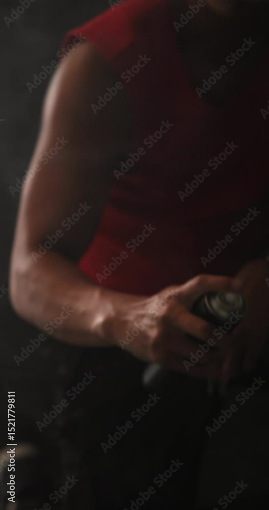 Vertical video: Man in red shirt creating dynamic motion with green smoke in studio Vertical video: Man in red shirt creating dynamic motion with green smoke in studio