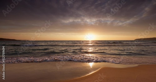 Sunrise over calm ocean beach shore with golden sun light on the sand, tropical sea sunrise with scenic cloudscape video