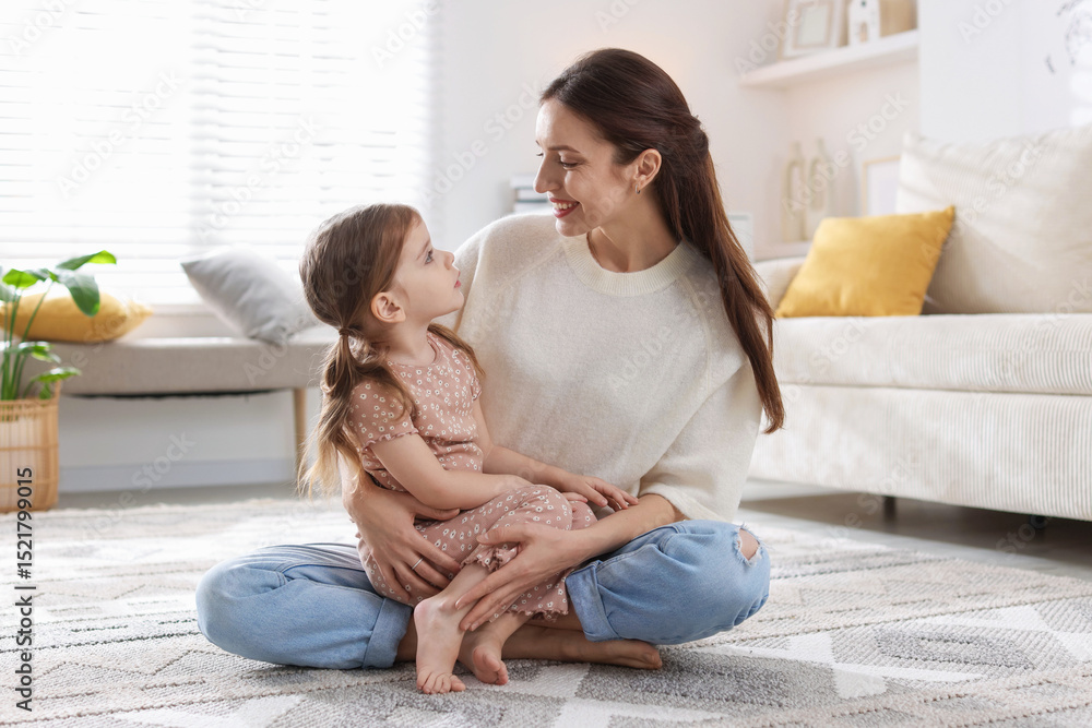 Happy mother with her cute little daughter on carpet at home Happy mother with her cute little daughter on carpet at home