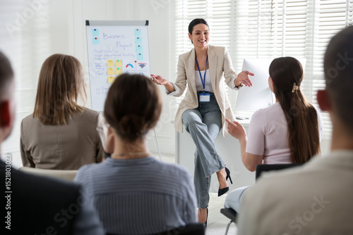 Tableau sur toile Woman giving public speech in front of audience indoors