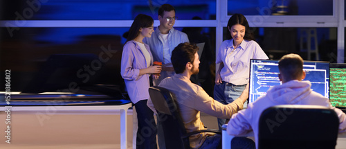 Female programmer working with her team in office at night