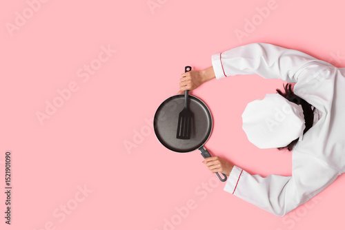 Young female cook with fryi...