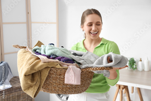 Young woman holding laundry...