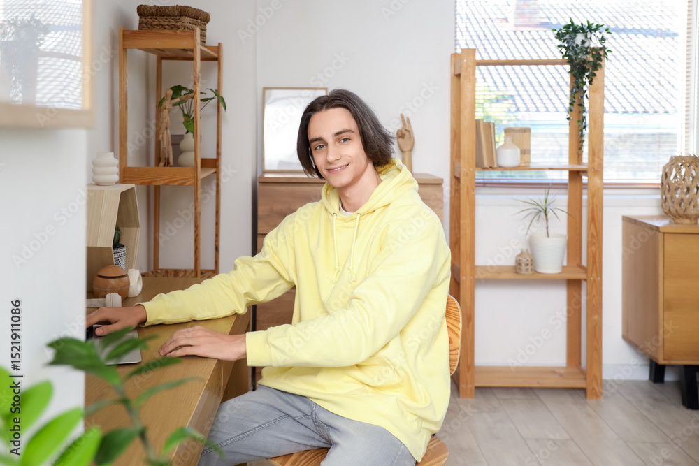 Young man using laptop on table at home Young man using laptop on table at home