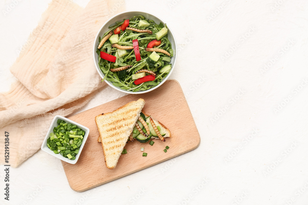 Naklejka premium Sandwich with fried maggots and bowl of fresh salad on white background