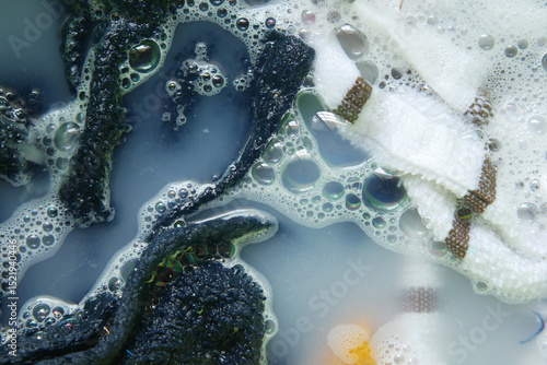 Photos Washing clothes with soap bubbles in basin water