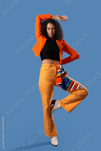 Stylish young woman in oran...