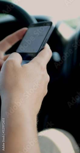 Man using a mobile phone to check email for work or text SMS. Driver reads news on mobile phone inside car. Screen is blurred. Focus on finger hand. Vertical shot. Closeup.