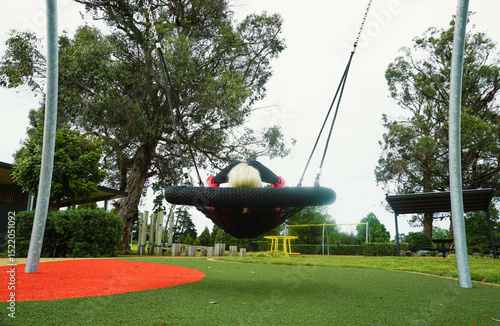 A woman playing in a public playground around Lake Rotoroa in Hamilton, New Zealand.