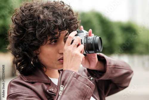Photos Young photographer taking photos with vintage camera in urban setting
