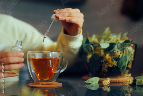 фотографія Person Puts Sweetener with Pipette into Tea Cup