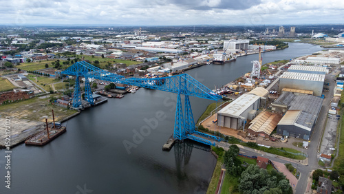 Aerial photograph of the historic Transporter Bridge spanning the River Tees in Middlesbrough, North East England. The image showcases the surrounding shipyards and industrial buildings